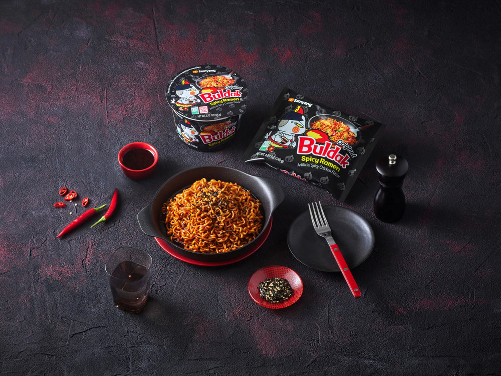 Buldak instant noodles with packaging on a dark textured surface