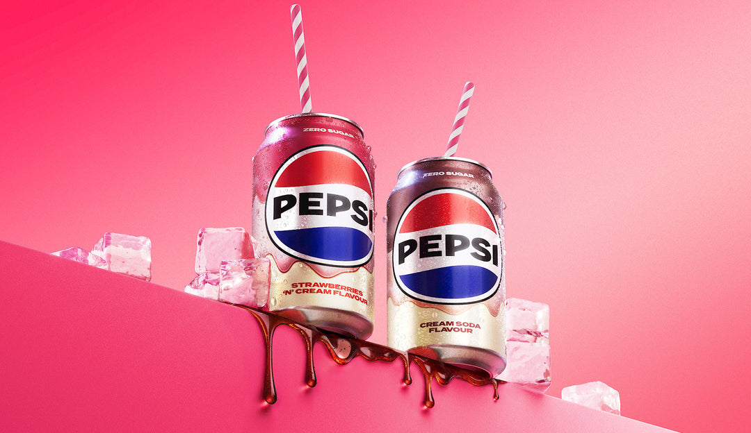 Two Pepsi cans with straws on a pink background
